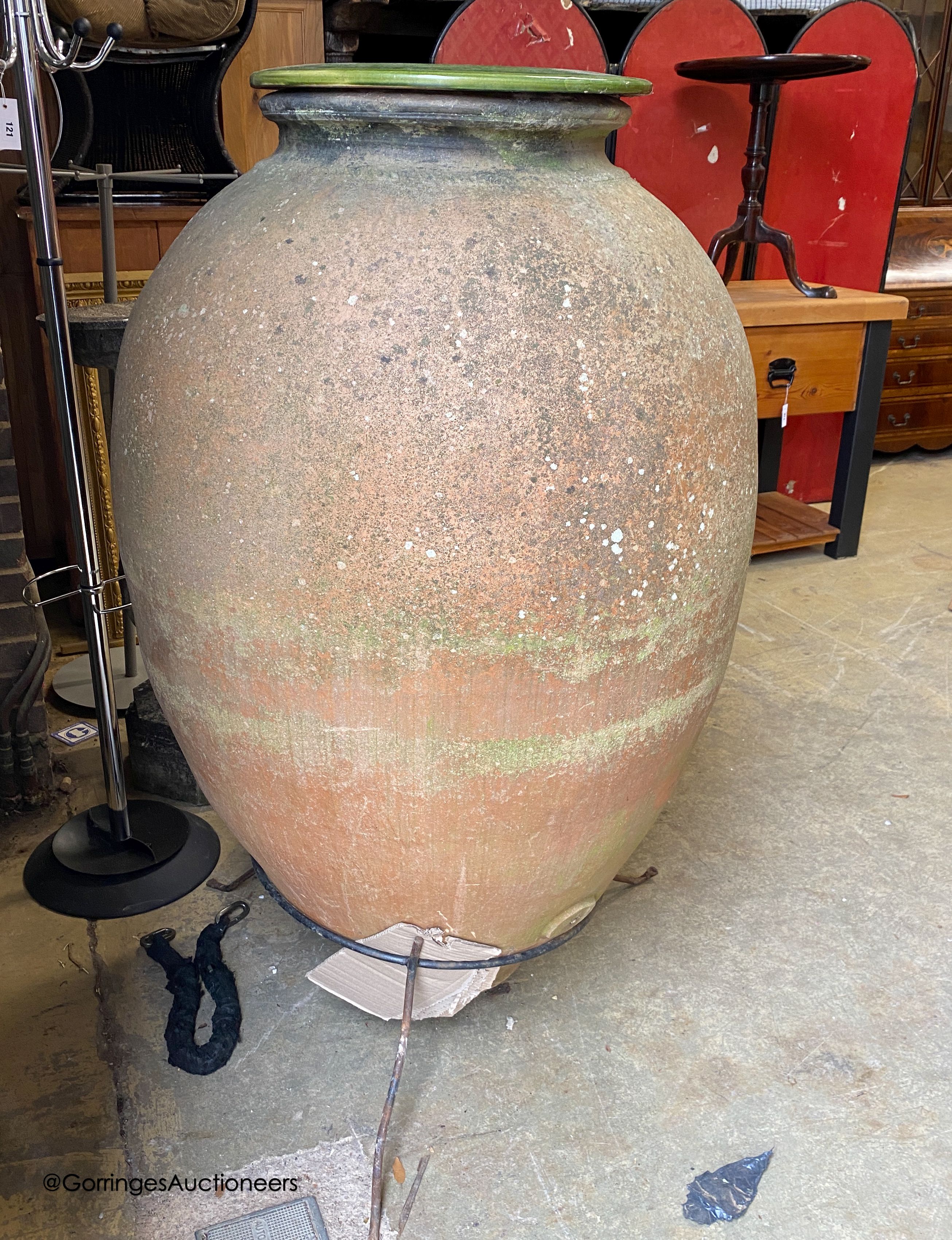 A large antique Italian oil jar, on iron stand with ceramic liner, height 144cm